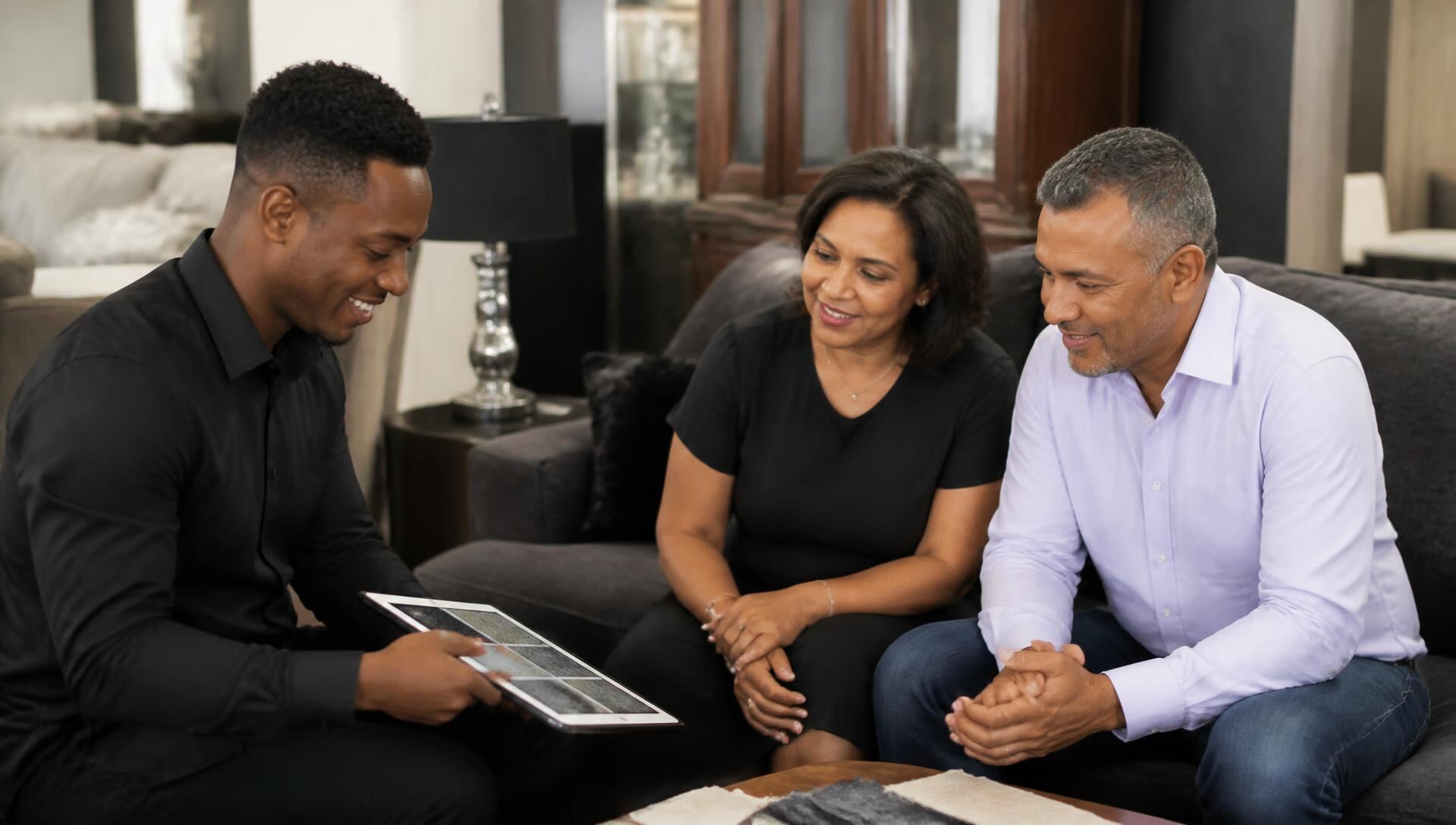 Salesperson helping a couple choose fabric for a new couch